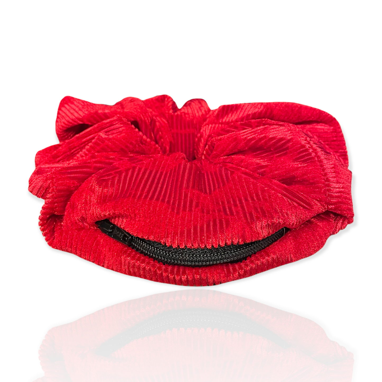 Oversized red corduroy scrunchie with hidden zipper for small items.